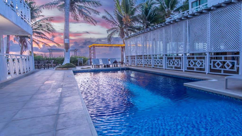 Hotel moderno frente al mar con piscina exterior, sillas reclinables y vista al océano