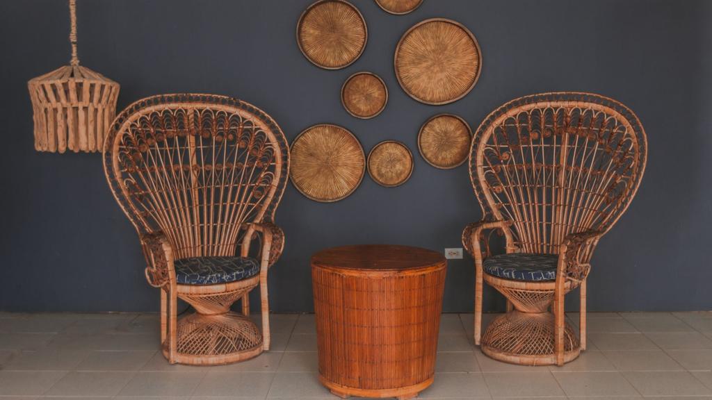 Lobby elegante del hotel con sillas de mimbre, mesa redonda de madera y decoración artesanal