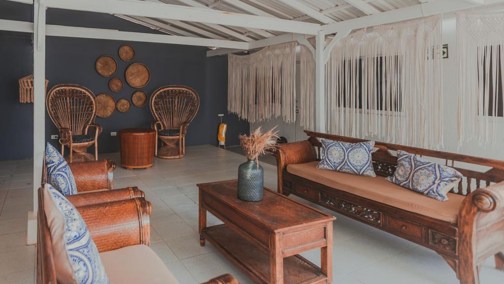 Lobby acogedor de estilo bohemio con sillas de mimbre, muebles de madera, cojines estampados