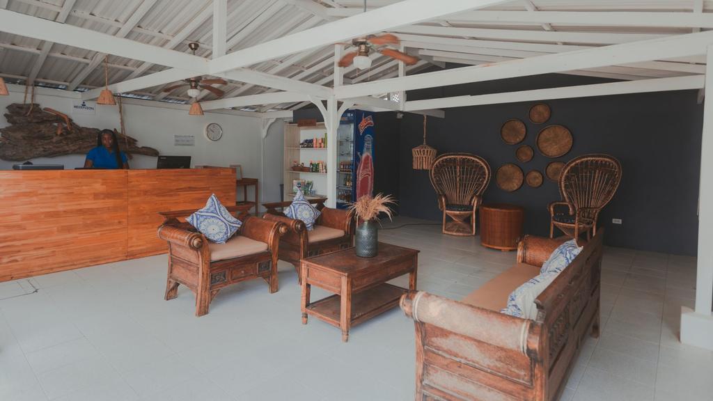 Lobby de hotel con recepción de madera, área de descanso acogedora, ventiladores de techo
