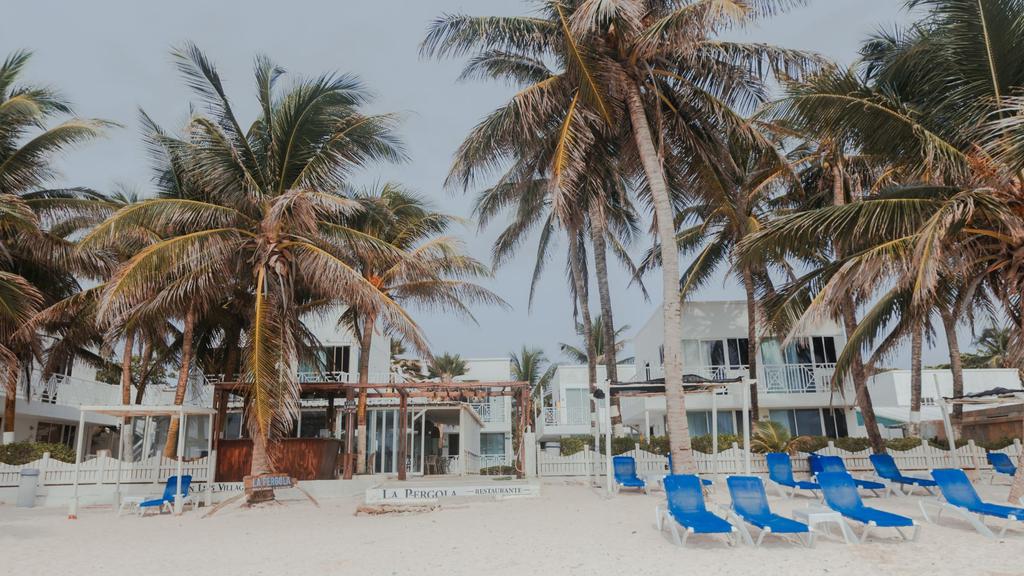 Club de playa al frente del hotel con asoleadoras para los huespedes